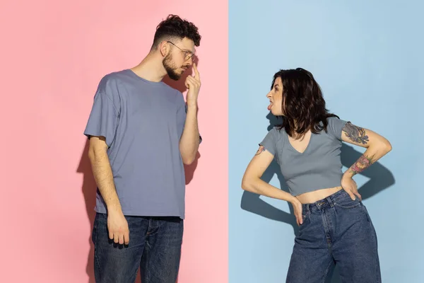 Retrato de joven hombre y chica emocional aislado sobre fondo de color azul y rosa de moda. Concepto de emociones humanas — Foto de Stock