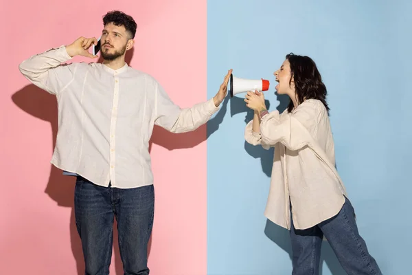Женатая пара, молодой эмоциональный мужчина и девушка изолированы на синем и розовом модном фоне. Человеческие эмоции, забота, концепция отношений — стоковое фото