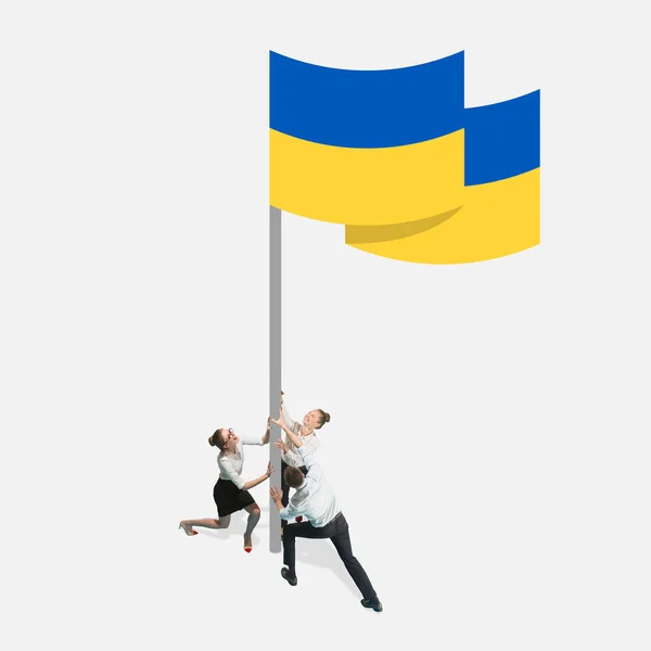 Εννοιολογική εικόνα. Νέοι peole holiding γιγαντιαία σημαία της Ουκρανίας απομονώνονται σε λευκό φόντο — Φωτογραφία Αρχείου