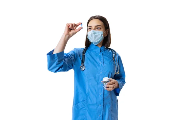 Πορτρέτο της νεαρής γυναίκας, γιατρός, θεραπευτικός ή ιατρικός σύμβουλος φορώντας μάσκα προσώπου και μπλε στολή απομονώνονται σε λευκό φόντο. — Φωτογραφία Αρχείου