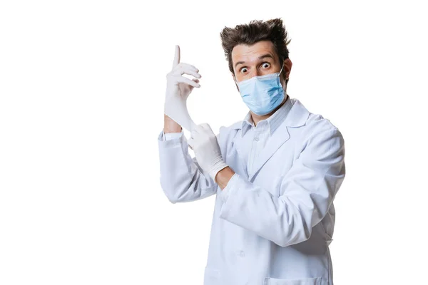 Portrait of young man, doctor wearing protective face mask and gloves isolated on white background. Concept of healthcare and medicine, war, help, treatment — Stock Photo, Image