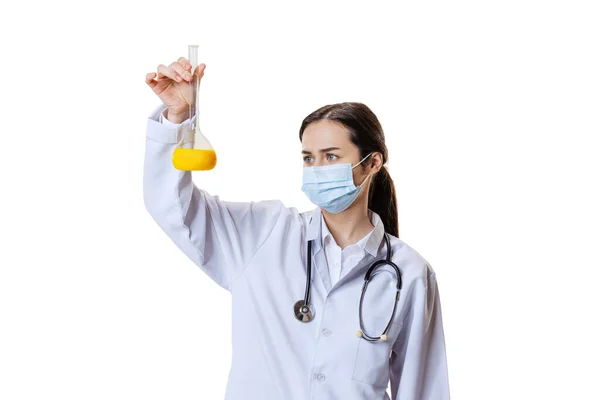 Porträtt av ung kvinna, läkare, terapeutisk eller medicinsk rådgivare bär ansiktsmask och vit uniform isolerad på vit bakgrund. Hälso- och sjukvård — Stockfoto