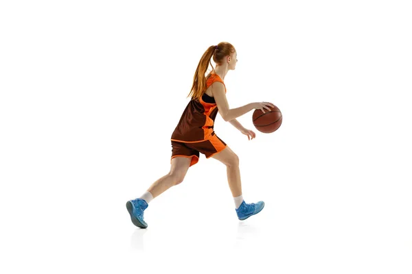 Retrato de niña, adolescente, jugador de baloncesto en movimiento, entrenamiento aislado oer blanco fondo del estudio. Vista lateral — Foto de Stock