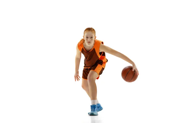 Full-length portret van jong meisje, basketbalspeler in beweging, training geïsoleerd over witte studio achtergrond — Stockfoto