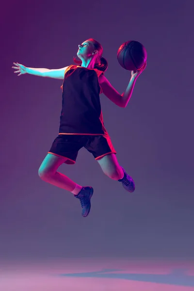 Retrato de una joven deportista, entrenamiento de jugador de baloncesto profesional aislado sobre fondo rosa púrpura degradado en neón —  Fotos de Stock