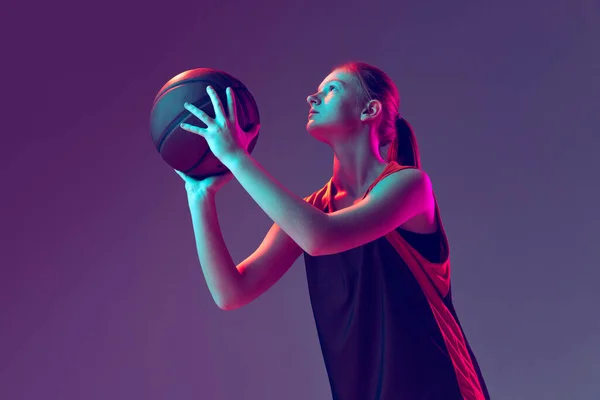 女运动员的形象，篮球运动员的训练，准备抛出一个孤立于深红色紫色背景之上的球 — 图库照片