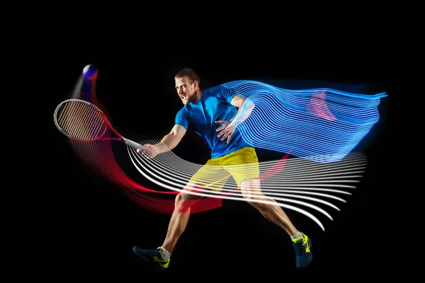 Jeden muž, profesionální tenista hrající tenis izolovaný na tmavém pozadí se smíšenými barevnými stipendii. Pojetí sportu, koníčku, výzev, míru, politiky — Stock fotografie