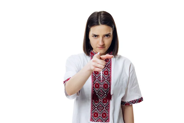 Porträt einer ernsten Frau in traditionellem ukrainischen Tuch - Stickereihemd, vyshyvanka zeigt isoliert auf Kamera vor weißem Studiohintergrund. — Stockfoto