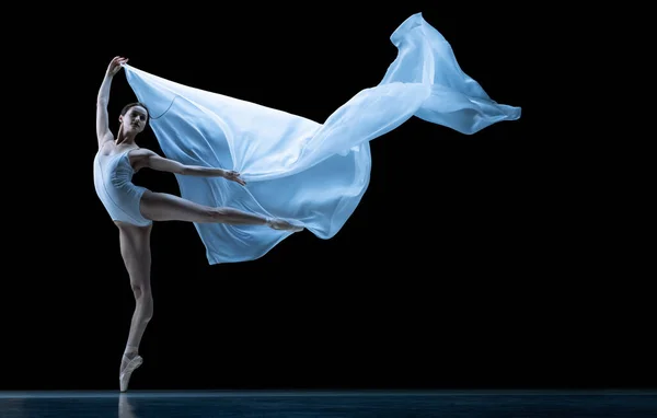 Graciosa bailarina clássica dançando com tecido sem peso isolado no fundo do estúdio preto em néon. Teatro, arte, beleza, graça, ação e conceito de movimento. — Fotografia de Stock