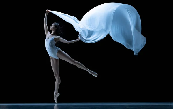 Graciosa bailarina clássica dançando com tecido sem peso isolado no fundo do estúdio preto em néon. Teatro, arte, beleza, graça, ação e conceito de movimento. — Fotografia de Stock