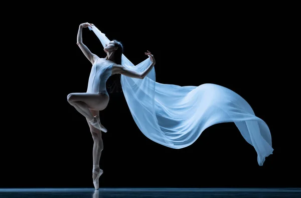 Красота. Классическая балерина танцует с невесомой тканью, выделенной на фоне черной студии в неоне. Театр, искусство, грация, действие и концепция движения. — стоковое фото