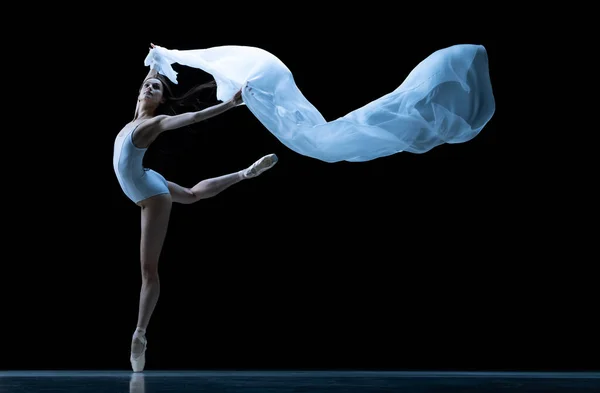 Graciosa bailarina clássica dançando com tecido sem peso isolado no fundo do estúdio preto em néon. Teatro, arte, beleza, graça, ação e conceito de movimento. — Fotografia de Stock