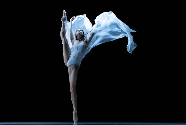 Graziosa ballerina classica che balla con tessuto senza peso isolato su sfondo nero in studio al neon. Teatro, arte, bellezza, grazia, azione e movimento concetto. — Foto Stock