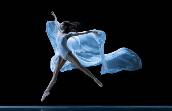 Graciosa bailarina clássica dançando com tecido sem peso isolado no fundo do estúdio preto em néon. Teatro, arte, beleza, graça, ação e conceito de movimento. — Fotografia de Stock