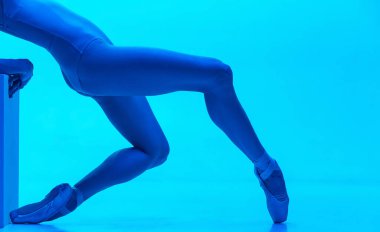 Yakın plan balerinler ince bacaklar sivri uçlu ayakkabılar, neon rengi stüdyo arka planında izole edilmiş. Sanat, hareket, eylem, esneklik, ilham kavramı.