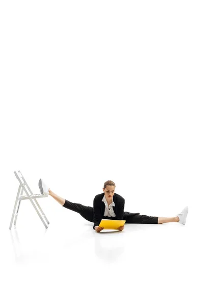 Retrato de una joven mujer hermosa, empleada en traje negro sentada sobre cordel, trabajando en proyectos aislados sobre fondo blanco —  Fotos de Stock