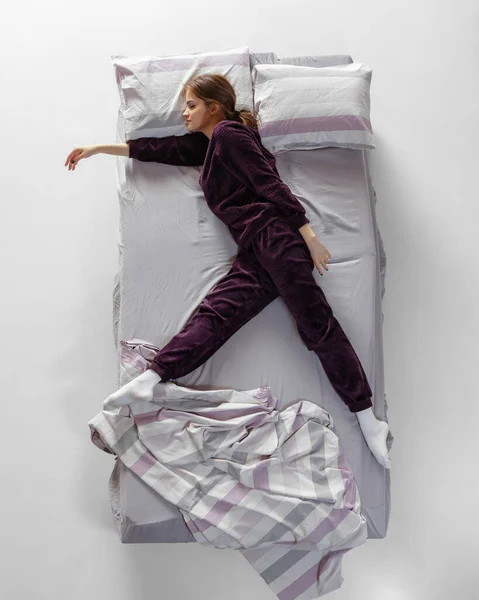 Kreatywny portret młodej dziewczyny ubranej w wino, piżamę śpiącej w dużym łóżku. Koncepcja zdrowia, wnętrze domu, czas relaksu, rodzina, marzenia — Zdjęcie stockowe