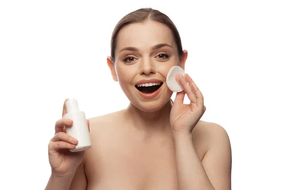 Portret van een mooie emotieve vrouw met een natuurlijk uitziende huid, lotion aanbrengen, geïsoleerd poseren over witte studio achtergrond — Stockfoto