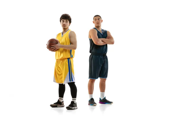 Porträtt av två unga basketspelare poserar isolerad på vit studio bakgrund. Rörelse, aktivitet, idrottskoncept. — Stockfoto