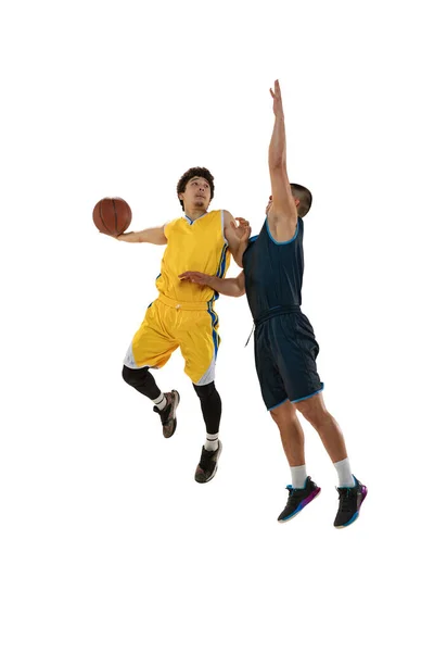 Plný portrét dvou mladých basketbalistů skákajících s míčem izolovaným na bílém pozadí studia. Pohyb, aktivita, sportovní pojmy. — Stock fotografie