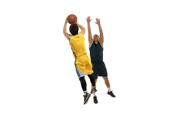 Plný portrét dvou mladých basketbalistů skákajících s míčem izolovaným na bílém pozadí studia. Pohyb, aktivita, sportovní pojmy. — Stock fotografie