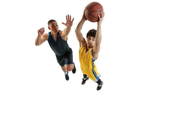 两名年轻篮球选手在白色工作室背景上与球隔离后跳跃的动态肖像。运动、活动、运动概念. — 图库照片