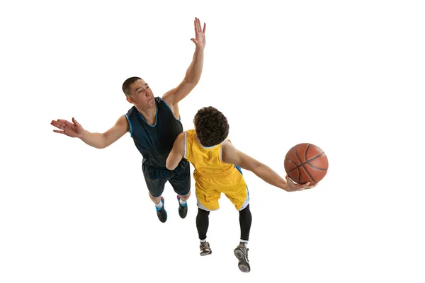 Visão superior de dois jovens jogadores de basquete treinando com bola isolada no fundo do estúdio branco. Movimento, atividade, conceitos de esporte. — Fotografia de Stock