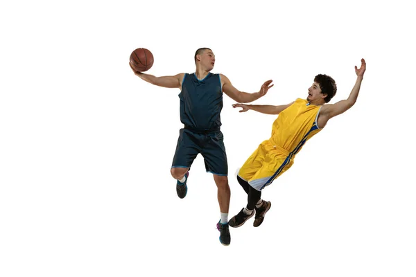 Вид сверху на двух юных баскетболистов, тренирующихся с мячом на белом студийном фоне. Понятия движения, активности, спорта. — стоковое фото