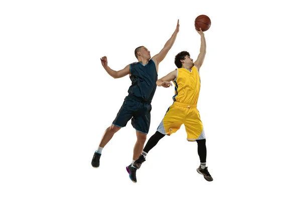 Dynamický portrét dvou mladých basketbalistů skákajících s míčem izolovaným na bílém pozadí studia. Pohyb, aktivita, sportovní pojmy. — Stock fotografie
