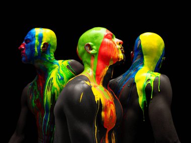 Sanat eserleri. Genç kel adamlardan yapılmış kolaj, siyah arka planda izole edilmiş çok renkli boyalarla kaplı çıplak göğüslü modeller. Yaratıcılık, sanat, güzellik