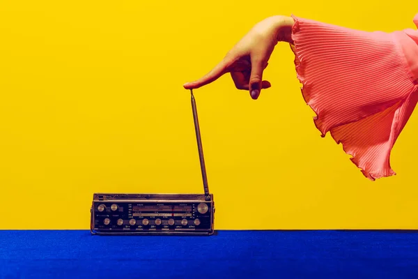 Velho rádio. Mão feminina tocando radior, sem fio isolado em fundo azul brilhante e amarelo. Vintage, estilo de moda retro. Fotografia Pop art. — Fotografia de Stock