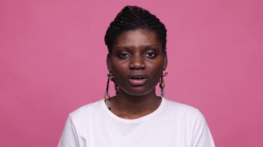 Beyaz tişört giyen neşeli genç kız pembe arka planda izole edilmemiş gülücük sözcüğüyle. 4 bin. Duygular konsepti