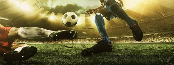 Primer plano de las piernas de fútbol, jugadores de fútbol en acción, movimiento en el estadio con linternas y puestos abarrotados. Concepto de deporte, competición, movimiento, superación. — Foto de Stock