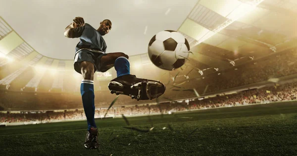 Professional soccer player in action at the stadium with flashlights hitting the ball for the winning goal, wide angle. Concept of sport, competition, movement, overcoming. — Stock Photo, Image