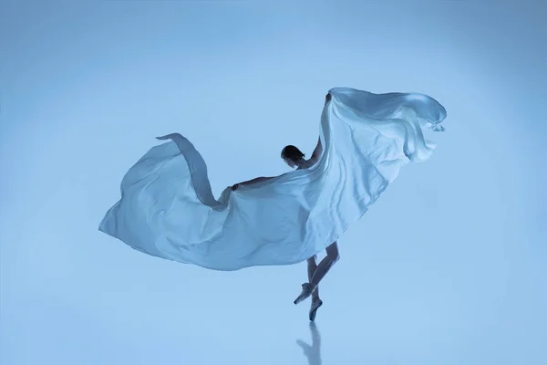 Portrét ohebné ženy, půvabná baletka tančící s látkou, látka izolovaná na modrém pozadí studia. Grace, umění, krása. Beztíže, citlivost. — Stock fotografie