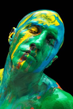 Çağdaş sanat eserleri. Siyah arka planda izole edilmiş rengarenk boyalarla kaplı gözleriyle yakın plan genç bir adam. İnsan vücudunda soyut sanat