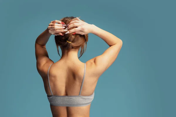 Strong back. Half-length image of beautiful sportive female back, shoulders  isolated over blue background Stock Photo by ©vova130555@gmail.com 558894814