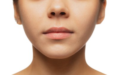 Beyaz stüdyo arka planında izole edilmiş kadın dudaklarının, yanaklarının ve burnunun yakın plan görüntüsü.