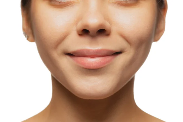 Gesneden close-up beeld van vrouwelijke lippen, wangen en neus geïsoleerd over witte studio bacground. Lachende schoonheid — Stockfoto