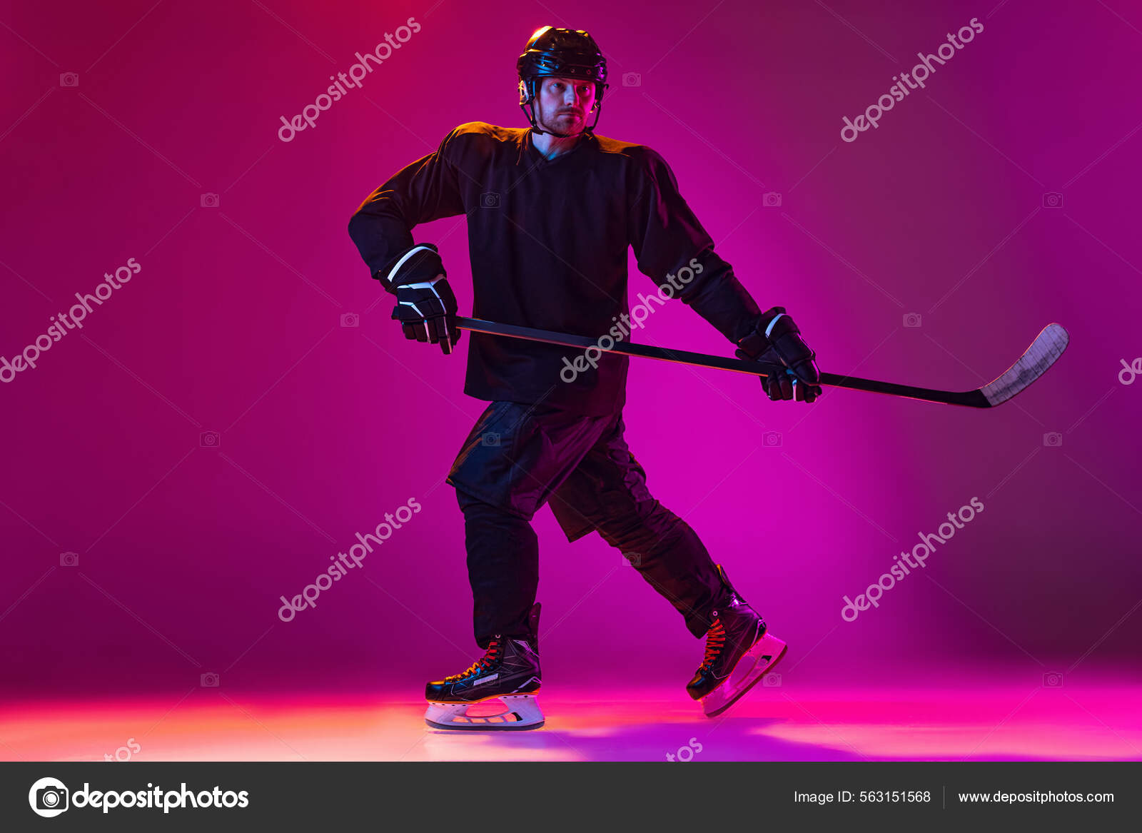 Man, professional hockey player training in special uniform with helmet isolated over pink background in neon