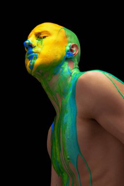 Kafasında ve omuzlarında siyah arka planda izole edilmiş koyu renkli boya ile kaplanmış, gözleri kapalı genç bir adamın yan görüş portresi.