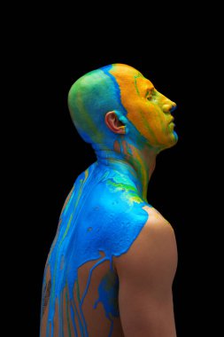 Kafasında ve omuzlarında siyah arka planda izole edilmiş kalın renkli boyalarla kaplanmış, kapalı gözlü bir adamın yan görüş portresi.