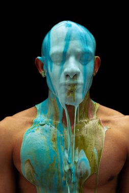 Kafasına kalın boya bulaşmış genç kaslı adamın portresi siyah arka planda izole edilmiş bir şekilde vücudundan aşağı akıyor.