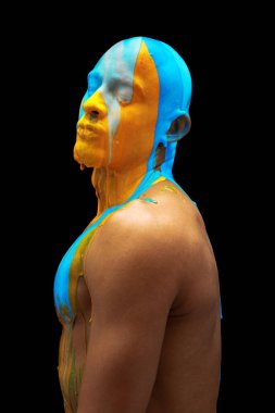 Siyah arka planda izole edilmiş kalın pembe boyayla kaplı genç kaslı adamın portresi.