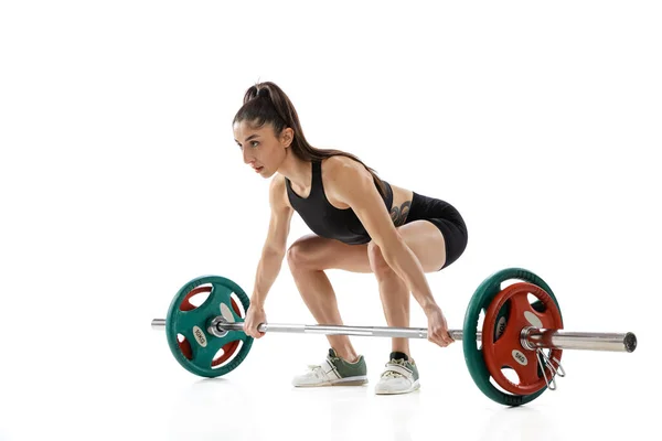 1人の若い強い女性の重量挙げワークアウト、白い背景に隔離された鐘。スポーツ、重量挙げの概念 — ストック写真