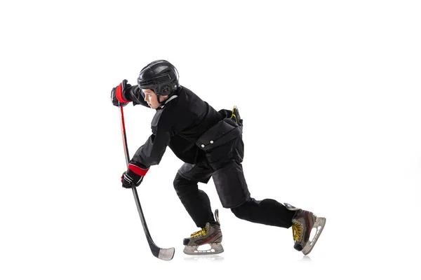 Concentration. Child, hockey player with the stick on ice court and white background. — ストック写真