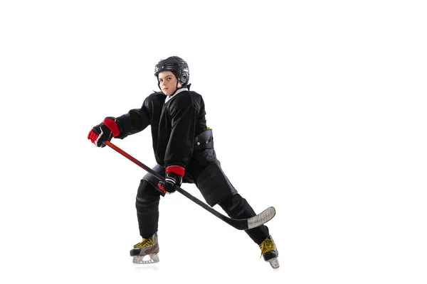 Concentración. Niño, jugador de hockey con el palo en la pista de hielo y fondo blanco. — Foto de Stock