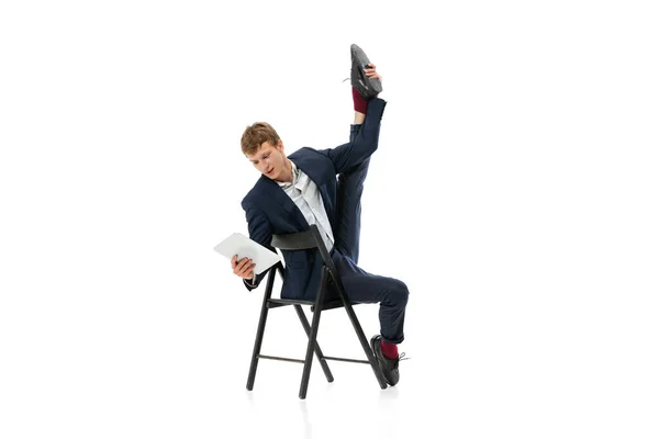 Retrato de homem bonito jovem, trabalhador de escritório sentado na cadeira de escritório e usando tablet isolado sobre fundo branco — Fotografia de Stock