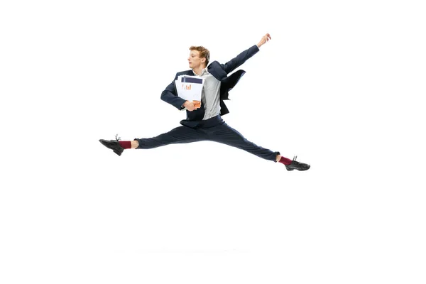 Giovane uomo in abito scuro che salta, volando isolato su sfondo bianco. Arte, movimento, azione, flessibilità, concetto di ispirazione. — Foto Stock