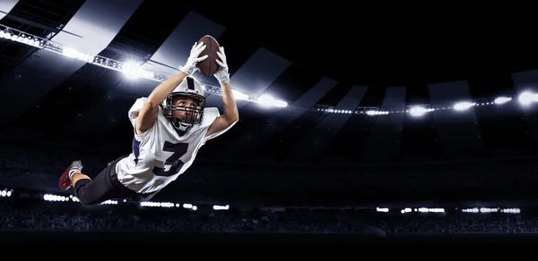 Retrato dinâmico de jogador de futebol americano masculino em equipamentos esportivos no estádio em movimento em fundo escuro com lanternas. Colagem, cartaz. Folheto para anúncio, projeto — Fotografia de Stock